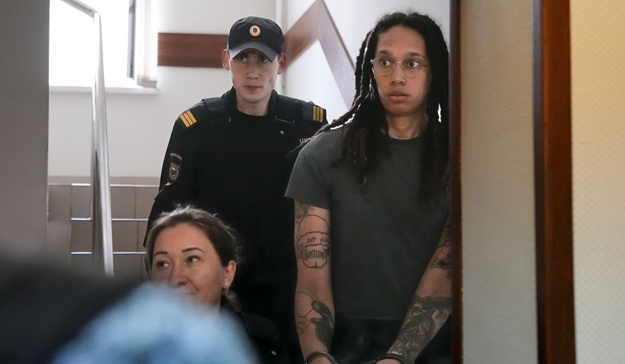 In this file photo, WNBA star and two-time Olympic gold medalist Brittney Griner is escorted to a courtroom for a hearing, in Khimki just outside Moscow, Russia, Monday, June 27, 2022.  (AP Photo/Alexander Zemlianichenko)  **FILE**