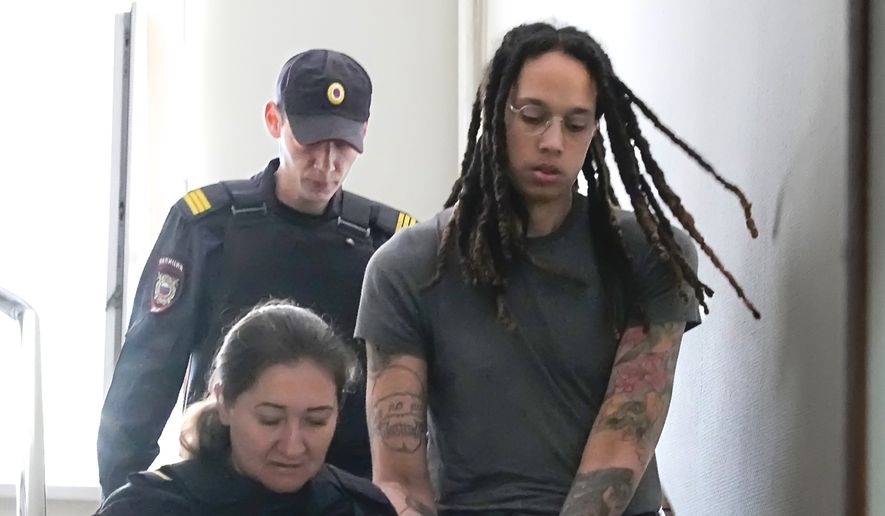 WNBA star and two-time Olympic gold medalist Brittney Griner is escorted to a courtroom for a hearing, in Khimki just outside Moscow, Russia, Monday, June 27, 2022. More than four months after she was arrested at a Moscow airport for cannabis possession, American basketball star Griner is to appear in court Monday for a preliminary hearing ahead of her trial. (AP Photo/Alexander Zemlianichenko)