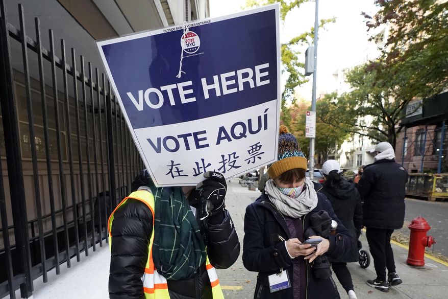 FILE — Poll workers direct voters outside Frank McCourt High School, on New York&#39;s Upper West Side, Nov. 3, 2020. A judge on Monday, June 27, 2022, blocked New York City from letting noncitizens vote for mayor and other municipal offices, a measure that Republicans challenged as unconstitutional. (AP Photo/Richard Drew)