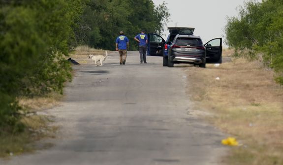 Searchers work at the scene, Tuesday, June 28, 2022, in San Antonio, where officials say dozens of people have been found dead and multiple others were taken to hospitals with heat-related illnesses after a semitrailer containing suspected migrants was found. (AP Photo/Eric Gay)