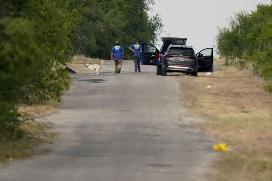 Searchers work at the scene, Tuesday, June 28, 2022, in San Antonio, where officials say dozens of people have been found dead and multiple others were taken to hospitals with heat-related illnesses after a semitrailer containing suspected migrants was found. (AP Photo/Eric Gay)
