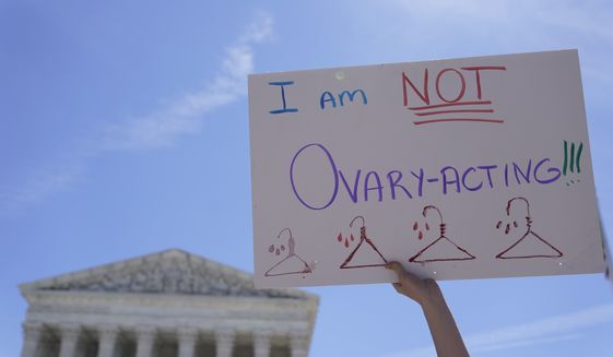 An abortion-rights activists holds a sign reading &quot;I am not Ovary-Acting,&quot; during the protests outside of the U.S. Supreme Court, on Tuesday, June 28, 2022, in Washington. (AP Photo/Mariam Zuhaib)