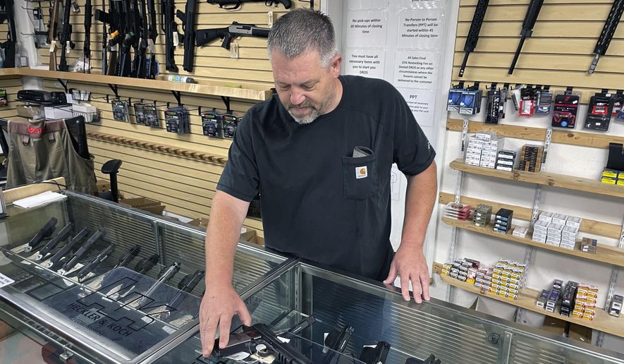 John Parkin, co-owner of Coyote Point Armory displays a handgun at his store in Burlingame, Calif., June 23, 2022. In response to the U.S. Supreme Court&#x27;s ruling that allows more people to carry concealed weapons, California lawmakers, on Tuesday, June 28, 2022, moved to boost requirements and limit where firearms may be carried while staying within the high court&#x27;s ruling. (AP Photo/Haven Daley, File)
