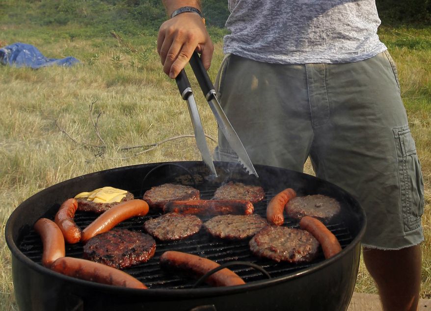 In this Wednesday, July 4, 2012 file photo, a man grills hamburgers and hot dogs in Arlington, Va. (AP Photo/Alex Brandon, File)