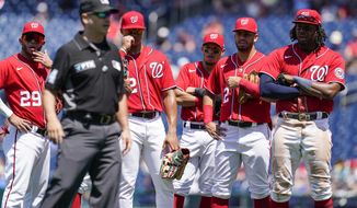 Members of the against the Washington Nationals watch as crew chief umpire Mark Wegner, second from left, decides a call during the fifth inning of a baseball game against the Pittsburgh Pirates at Nationals Park, Wednesday, June 29, 2022, in Washington. (AP Photo/Alex Brandon)