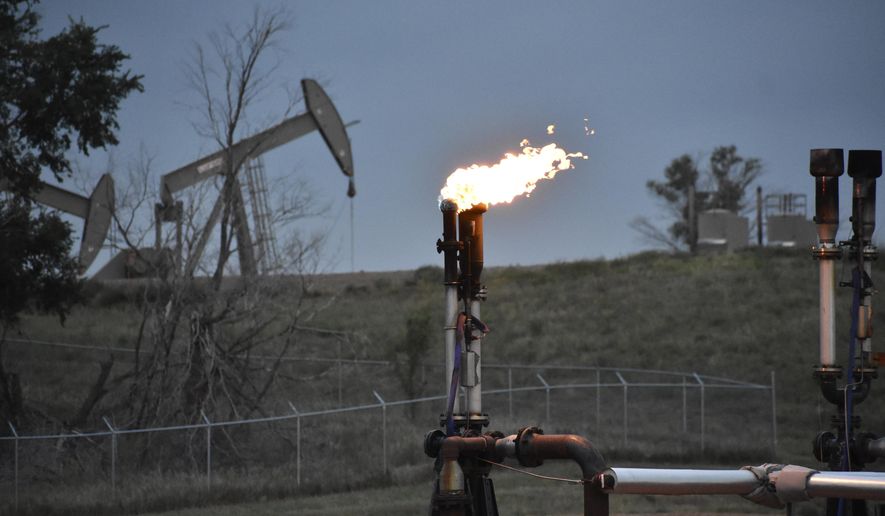 A flare to burn methane from oil production is seen on a well pad near Watford City, N.D., on Aug. 26, 2021. The U.S. government this week is holding its first onshore oil and gas sales from public lands since President Joe Biden took office. (AP Photo/Matthew Brown, File)