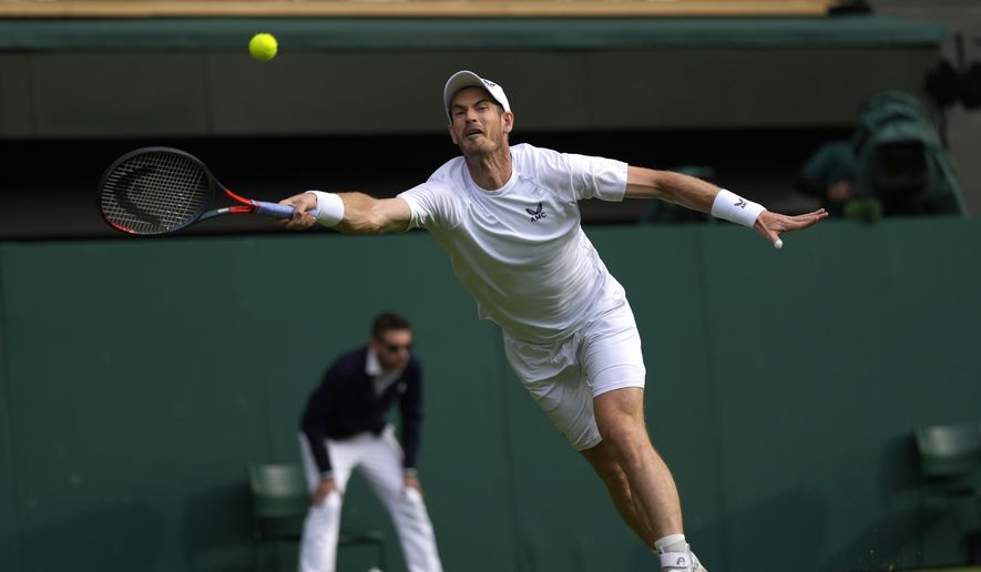 Britain&#39;s Andy Murray returns the ball to John Isner of the US during their singles tennis match on day three of the Wimbledon tennis championships in London, Wednesday, June 29, 2022. (AP Photo/Alastair Grant)