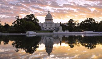 The U.S. Capitol is seen at dawn, near a reflecting pool on the Mall. (AP Photo)