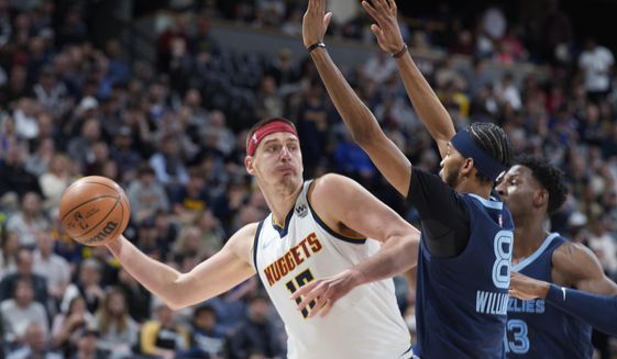 Denver Nuggets center Nikola Jokic looks to pass the ball as Memphis Grizzlies guard Ziaire Williams, front, and forward Jaren Jackson Jr. defend during the first half of an NBA basketball game April 7, 2022, in Denver. Jokic and the Nuggets agreed Thursday, June 30, to a $264 supermax extension, according to a person with direct knowledge of the negotiations who spoke to The Associated Press on condition of anonymity because neither the player nor team announced the agreement. (AP Photo/David Zalubowski, File) **FILE**