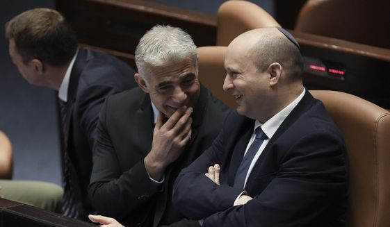 Israeli Prime Minister Naftali Bennett, right, and Foreign Minister Yair Lapid talk ahead of the vote on a bill to dissolve parliament, at the Knesset, Israel&#39;s parliament, in Jerusalem, Thursday, June 30, 2022. (AP Photo/Ariel Schalit)