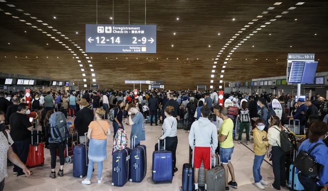 Passengers wait to check-in in a terminal of Charles de Gaulle airport, Friday, July 1, 2022, at Roissy airport, north of Paris. Flights from Charles de Gaulle airport in Paris and other French airports faced disruptions Friday as airport workers held a strike and protests to demand salary hikes to keep up with inflation. It&#x27;s the latest trouble to hit global airports this summer, as travel resurges after two years of virus restrictions. (AP Photo/ Thomas Padilla)