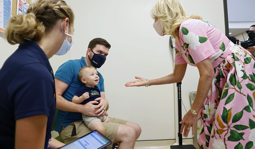 First lady Jill Biden greets Matthew Morgan and his almost 11-month-old Avery, as they wait for Avery to receive his first COVID-19 vaccination at the Henrico County Health Department East Clinic on Friday, July 1, 2022 in Richmond, Va. The visit sought to highlight the recent authorization and recommendation of COVID-19 vaccines for children under age five and was her first visit to a 6-month to 5-year-old pediatric COVID-19 vaccination clinic since the CDC recommended the use of COVID-19 vaccines for this age group. (Eva Russo/Richmond Times-Dispatch via AP)