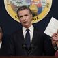 California Gov. Gavin Newsom displays a bill he just signed that shields abortion providers and volunteers in California from civil judgements from out-of-state courts during a news conference in Sacramento, Calif., Friday, June 24, 2022. Newsom angrily denounced the Supreme Court decision to overturn Roe v. Wade. (AP Photo/Rich Pedroncelli, File)