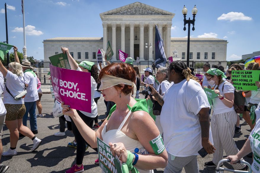 Mahayana Landowne, of Brooklyn, N.Y., wears a &amp;quot;Lady Justice&amp;quot; costume as she marches past the Supreme Court during a protest for abortion-rights, Thursday, June 30, 2022, in Washington. (AP Photo/Jacquelyn Martin)