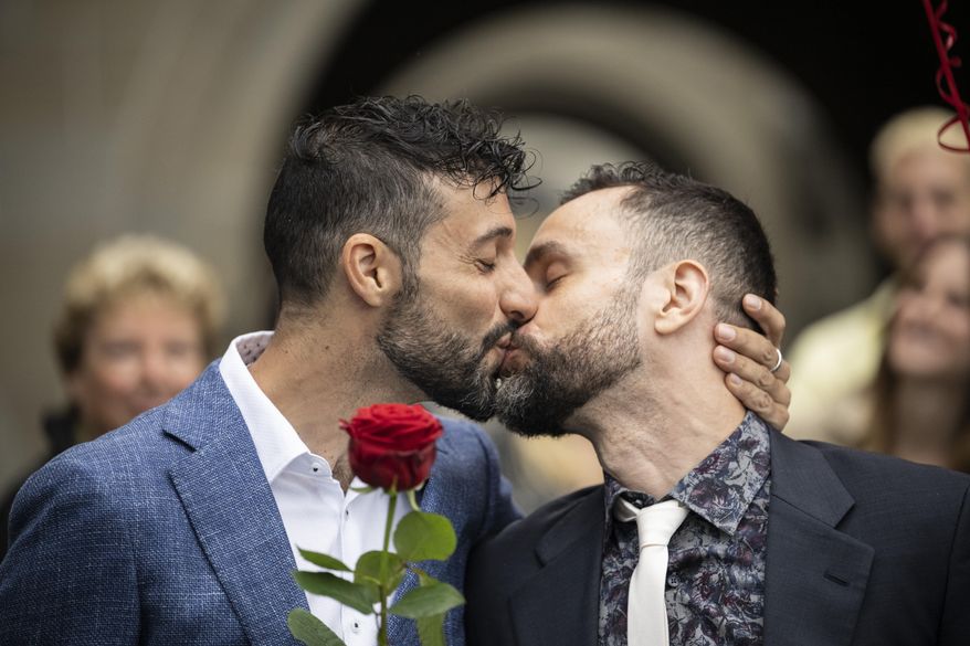 Luca Morreale and Stefano Perfetti kiss after converting their registered partnership into marriage, at the registry office in Zurich, picture taken on Friday, July 1, 2022.  After a yes vote in the &amp;quot;Marriage for All&amp;quot; vote last fall, from July 1, same-sex couples marriage for the first time in Switzerland. (Ennio Leanza/Keystone via AP)
