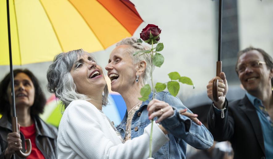 Annett Babinsky, right, and Laura Suarez celebrate their marriage at the registry office &#39;Amtshaus&#39; in Zurich, Switzerland, Friday, July 1, 2022.  After a yes vote in the &amp;quot;Marriage for All&amp;quot; vote last fall, from July 1, same-sex couples marriage for the first time in Switzerland. (Ennio Leanza/Keystone via AP)