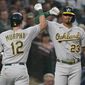 Oakland Athletics&#39; Sean Murphy (12) is congratulated by Christian Bethancourt (23) after Murphy hit a solo home run against the Seattle Mariners during the seventh inning of a baseball game Friday, July 1, 2022, in Seattle. (AP Photo/Ted S. Warren)