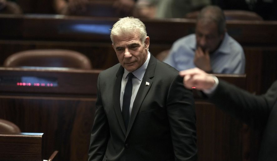 Israeli Foreign Minister Yair Lapid, center, arrives at the plenum ahead of the vote on a bill to dissolve parliament, at the Knesset, Israel&#39;s parliament, in Jerusalem, Thursday, June 30, 2022. Lapid will serve as caretaker prime minister until elections this fall. It would be Israel&#39;s fifth election in under four years. (AP Photo/Ariel Schalit)