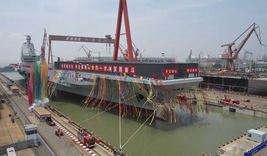 In this photo released by Xinhua News Agency, coloured smoke mark the launch ceremony for China&#39;s third aircraft carrier christened Fujian at a dry dock in Shanghai on Friday, June 17, 2022. China on Friday launched its third aircraft carrier, the first such ship to be both designed and built entirely within the country. (Li Gang/Xinhua via AP)