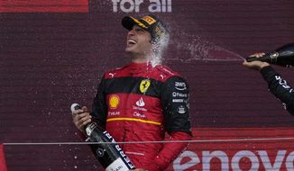 Ferrari driver Carlos Sainz of Spain celebrates on the podium after winning the British Formula One Grand Prix at the Silverstone circuit, in Silverstone, England, Sunday, July 3, 2022. (AP Photo/Matt Dunham)