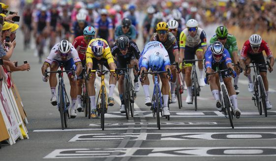 Stage winner Netherlands&#39; Dylan Groenewegen, center, pushes his bicycle over the finish line ahead of second placed Belgium&#39;s Wout Van Aert, wearing the overall leader&#39;s yellow jersey, third placed Belgium&#39;s Jasper Philipsen, right, and Slovakia&#39;s Peter Sagan, far left, during the third stage of the Tour de France cycling race over 182 kilometers (113 miles) with start in Vejle and finish in Sonderborg, Denmark, Sunday, July 3, 2022. (AP Photo/Daniel Cole)