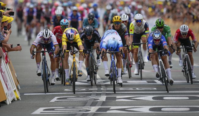 Stage winner Netherlands&#x27; Dylan Groenewegen, center, pushes his bicycle over the finish line ahead of second placed Belgium&#x27;s Wout Van Aert, wearing the overall leader&#x27;s yellow jersey, third placed Belgium&#x27;s Jasper Philipsen, right, and Slovakia&#x27;s Peter Sagan, far left, during the third stage of the Tour de France cycling race over 182 kilometers (113 miles) with start in Vejle and finish in Sonderborg, Denmark, Sunday, July 3, 2022. (AP Photo/Daniel Cole)