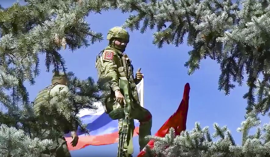 In this handout photo released by Russian Defense Ministry Press Service on Sunday, July 3, 2022, Russian soldiers set a Russian national flag and a replica of the Victory banner atop of the administration after capturing the eastern village of Bilohorivka which is now a territory under the Government of the Luhansk People&#39;s Republic control, eastern Ukraine. (Russian Defense Ministry Press Service via AP)