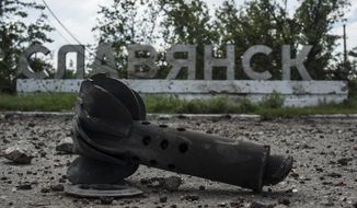 A part of the mortar shell is seen in front of a sign that reads &#x27;Slovyansk&#x27;, after heavy fighting between pro-Russian fighters and Ukrainian government troops just outside Slovyansk, eastern Ukraine, Wednesday, July 9, 2014. The eastern Ukrainian city of Slovyansk was occupied by pro-Russian separatists for months in 2014. Now its people are preparing to defend their community again as the fighting draws closer and invites a major battle. Slovyansk is a city of splintered loyalties, with some residents antagonistic toward Kyiv or nostalgic for their Soviet past. (AP Photo/Evgeniy Maloletka, File)