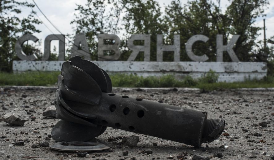 A part of the mortar shell is seen in front of a sign that reads &#39;Slovyansk&#39;, after heavy fighting between pro-Russian fighters and Ukrainian government troops just outside Slovyansk, eastern Ukraine, Wednesday, July 9, 2014. The eastern Ukrainian city of Slovyansk was occupied by pro-Russian separatists for months in 2014. Now its people are preparing to defend their community again as the fighting draws closer and invites a major battle. Slovyansk is a city of splintered loyalties, with some residents antagonistic toward Kyiv or nostalgic for their Soviet past. (AP Photo/Evgeniy Maloletka, File)