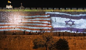 Israeli authorities project an image of the Israeli and U.S. flags on the walls of Jerusalem&#x27;s Old City in honor of July Fourth, Monday, July 4, 2022. President Joe Biden is set to visit Israel and the occupied West Bank next week as part of a broader trip to the Middle East. (AP Photo/Mahmoud Illean)