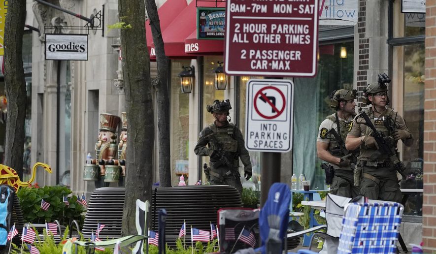 Law enforcement search after a mass shooting at the Highland Park Fourth of July parade in downtown Highland Park, Ill., a Chicago suburb on Monday, July 4, 2022. (AP Photo/Nam Y. Huh)