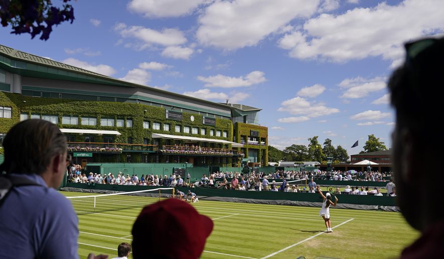 Spectators watch as Italy&#39;s Georgia Pedone serves during a Girls singles match on day eight of the Wimbledon tennis championships in London, Monday, July 4, 2022. (AP Photo/Alberto Pezzali)