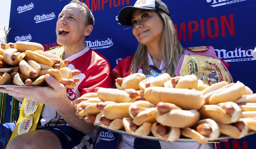 Joey Chestnut and Miki Sudo pose with 63 and 40 hot dogs, respectively, after winning the Nathan&#39;s Famous Fourth of July hot dog eating contest in Coney Island on Monday, July 4, 2022, in New York. (AP Photo/Julia Nikhinson)