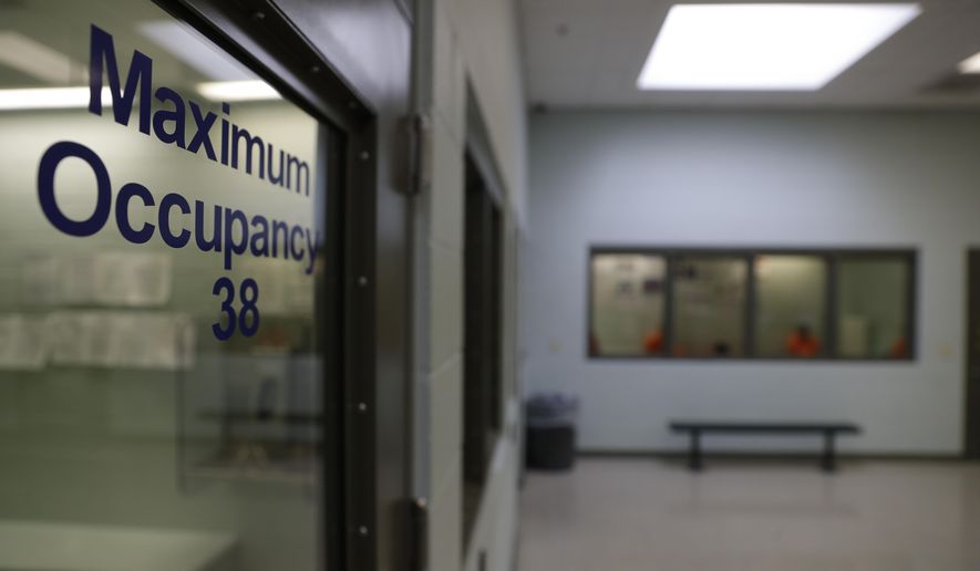 In this Aug. 28, 2019, photo, detainees (background) wait to be processed at the Adelanto ICE Processing Center in Adelanto, Calif. (AP Photo/Chris Carlson) **FILE**