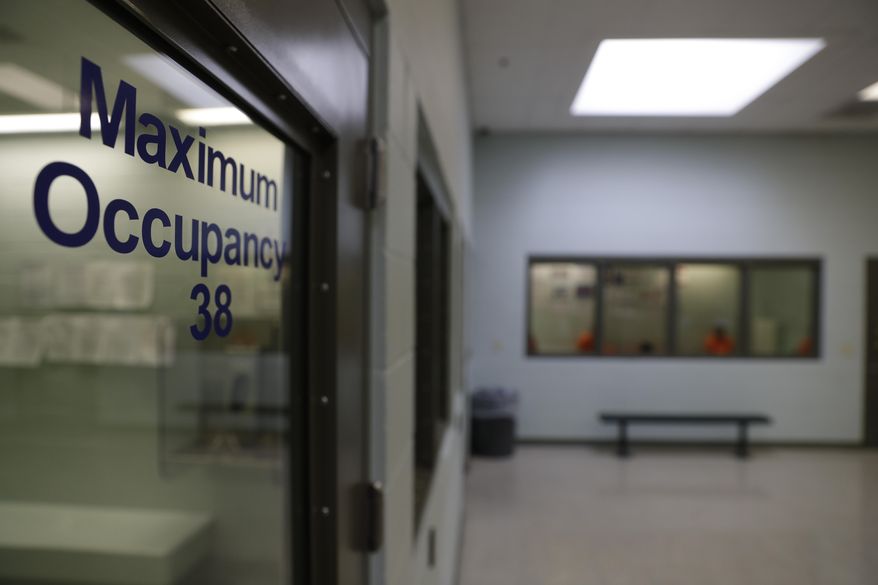 In this Aug. 28, 2019, photo, detainees (background) wait to be processed at the Adelanto ICE Processing Center in Adelanto, Calif. (AP Photo/Chris Carlson) **FILE**