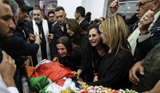 Colleagues and friends react as the Palestinian flag-draped body of veteran Al Jazeera journalist Shireen Abu Akleh is brought to the news channel&#39;s office in the West Bank city of Ramallah, Wednesday, May 11, 2022. U.S. officials have concluded that gunfire from Israeli positions likely killed Abu Akleh but that there was “no reason to believe” her shooting was intentional, the State Department said Monday, July 4, 2022. (Abbas Momani/Pool via AP) **FILE**