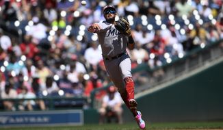 Miami Marlins shortstop Miguel Rojas throws to first to put out Washington Nationals&#39; Lane Thomas during the third inning of a baseball game, Monday, July 4, 2022, in Washington. (AP Photo/Nick Wass)