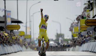 Belgium&#39;s Wout Van Aert, wearing the overall leader&#39;s yellow jersey celebrates as he crosses the finish line to win the fourth stage of the Tour de France cycling race over 171.5 kilometers (106.6 miles) with start in Dunkerque and finish in Calais, France, Tuesday, July 5, 2022. (AP Photo/Daniel Cole)