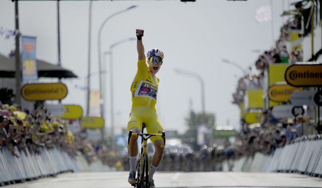 Belgium&#x27;s Wout Van Aert, wearing the overall leader&#x27;s yellow jersey celebrates as he crosses the finish line to win the fourth stage of the Tour de France cycling race over 171.5 kilometers (106.6 miles) with start in Dunkerque and finish in Calais, France, Tuesday, July 5, 2022. (AP Photo/Daniel Cole)