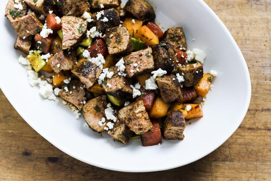 This image released by Milk Street shows a recipe for Chili-rubbed Pork with Cucumber-Melon Salad. (Milk Street via AP)