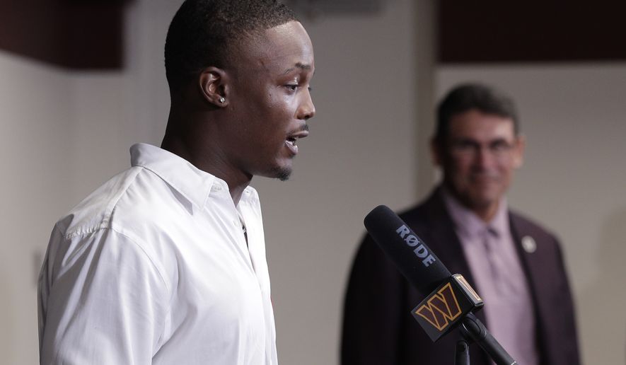 Washington Commanders NFL football team new wide receiver Terry McLaurin, left, talks to the media as head coach Ron Rivera, right, looks on during a press conference at Inova Sports Performance Center in Ashburn, Va., Wednesday, July 6, 2022.  (AP Photo/Luis M. Alvarez)