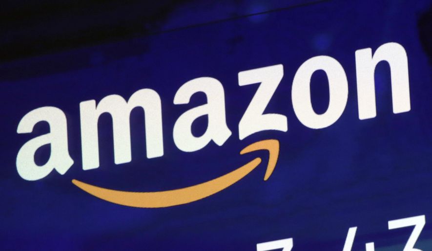 The logo for Amazon is displayed on a screen at the Nasdaq MarketSite, July 27, 2018. Britain’s competition watchdog is planning to investigate whether Amazon is harming competition and hurting consumers by giving an unfair advantage to merchants that pay for extra services. (AP Photo/Richard Drew, File)