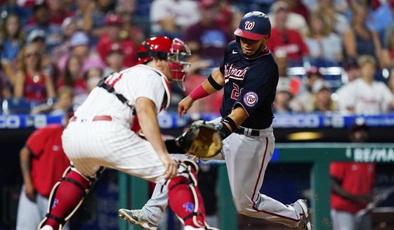 Washington Nationals&#39; Keibert Ruiz, right, scores past Philadelphia Phillies catcher J.T. Realmuto on a two-run double by Luis Garcia during the seventh inning of a baseball game, Wednesday, July 6, 2022, in Philadelphia. (AP Photo/Matt Slocum)