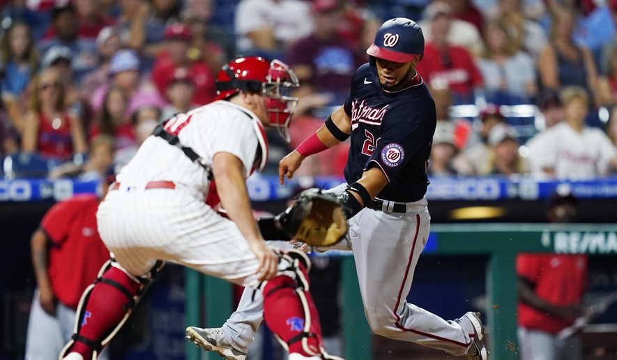 Washington Nationals&#x27; Keibert Ruiz, right, scores past Philadelphia Phillies catcher J.T. Realmuto on a two-run double by Luis Garcia during the seventh inning of a baseball game, Wednesday, July 6, 2022, in Philadelphia. (AP Photo/Matt Slocum)