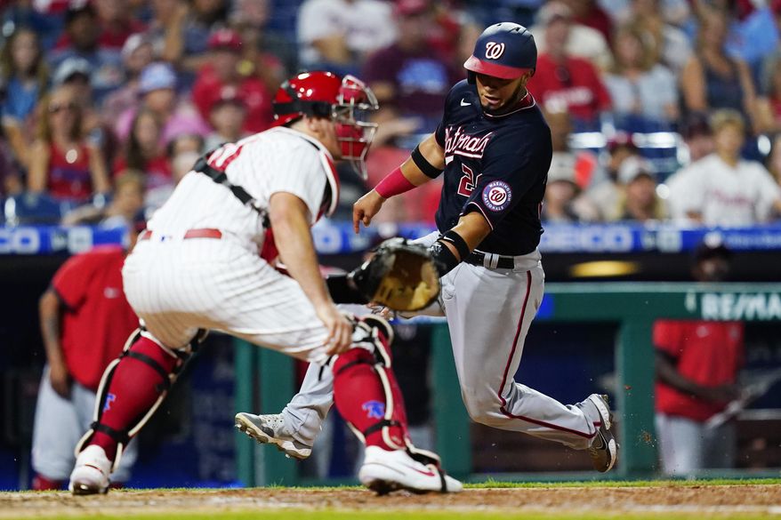 Washington Nationals&#39; Keibert Ruiz, right, scores past Philadelphia Phillies catcher J.T. Realmuto on a two-run double by Luis Garcia during the seventh inning of a baseball game, Wednesday, July 6, 2022, in Philadelphia. (AP Photo/Matt Slocum)