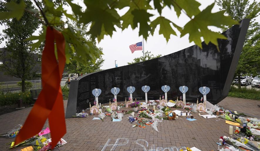 A memorial to the seven people killed and others injured in Monday&#39;s Fourth of July mass shooting grows at a veterans memorial, Wednesday, July 6, 2022, in Highland Park, Ill., a Chicago suburb. (AP Photo/Charles Rex Arbogast)
