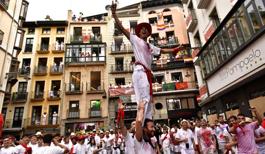 Revellers celebrate while waiting for the launch of the &#39;Chupinazo&#39; rocket, to mark the official opening of the 2022 San Fermin fiestas in Pamplona, Spain, Wednesday, July 6, 2022. The blast of a traditional firework opens Wednesday nine days of uninterrupted partying in Pamplona&#39;s famed running-of-the-bulls festival which was suspended for the past two years because of the coronavirus pandemic. (AP Photo/Alvaro Barrientos)