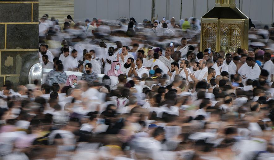 In this photo taken with low shutter speed, Muslim pilgrims pray as others circumambulate around the Kaaba, the cubic building at the Grand Mosque, in Mecca, Saudi Arabia, Wednesday, July 6, 2022. Muslim pilgrims are converging on Saudi Arabia&#39;s holy city of Mecca for the largest hajj since the coronavirus pandemic severely curtailed access to one of Islam&#39;s five pillars. (AP Photo/Amr Nabil)