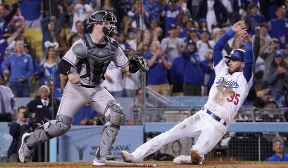 Los Angeles Dodgers&#39; Cody Bellinger, right, scores the winning run on a single by Mookie Betts as Colorado Rockies catcher Brian Serven waits for the ball during the ninth inning of a baseball game Wednesday, July 6, 2022, in Los Angeles. (AP Photo/Mark J. Terrill)