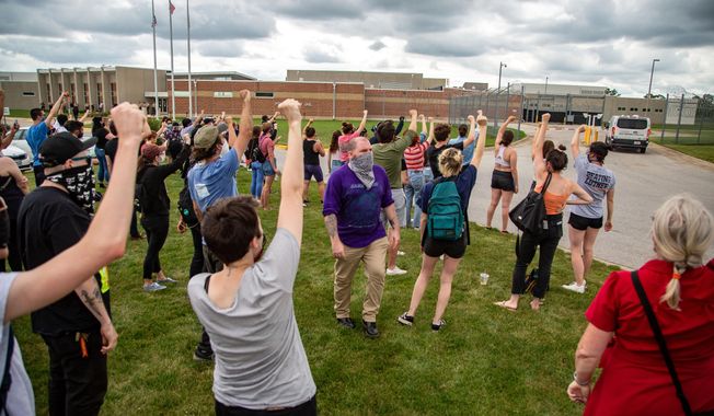 Protestors chant &amp;quot;Let them go&amp;quot; as Des Moines police vans arrive at the Polk County Jail after protestors were arrested outside the Capitol, in Des Moines, Iowa, on Wednesday, July 1, 2020. Two central Iowa police officers are suing a sitting Des Moines City Council member and five other people who participated in a racial justice protest in 2020, and are seeking an unspecified amount in damages in what experts say is a legal move rarely taken by police and other first responders.  (Zach Boyden-Holmes/The Des Moines Register via AP)